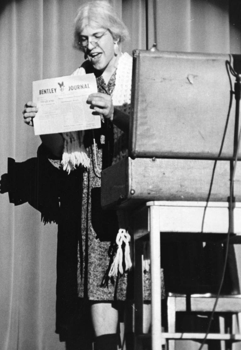 Bentley student holding Bentley Journal at talent show