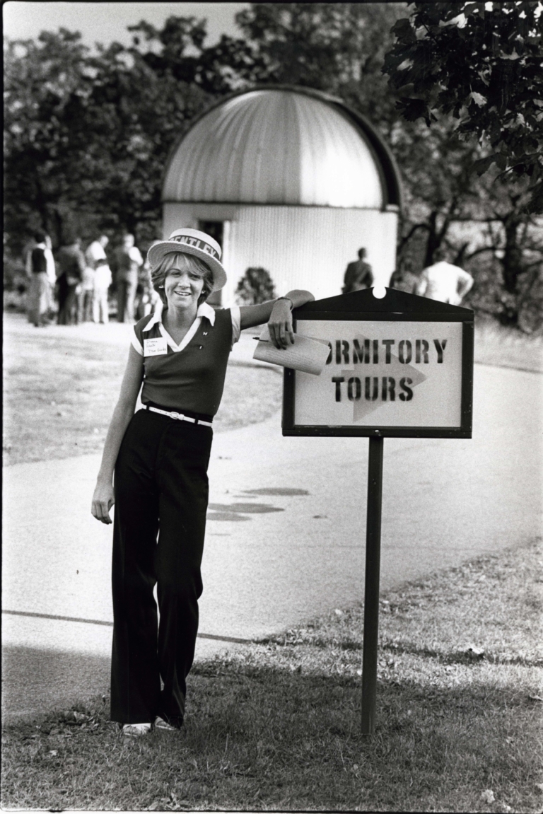 Tour guide waiting to give dormitory tours with the original Observatory in the background